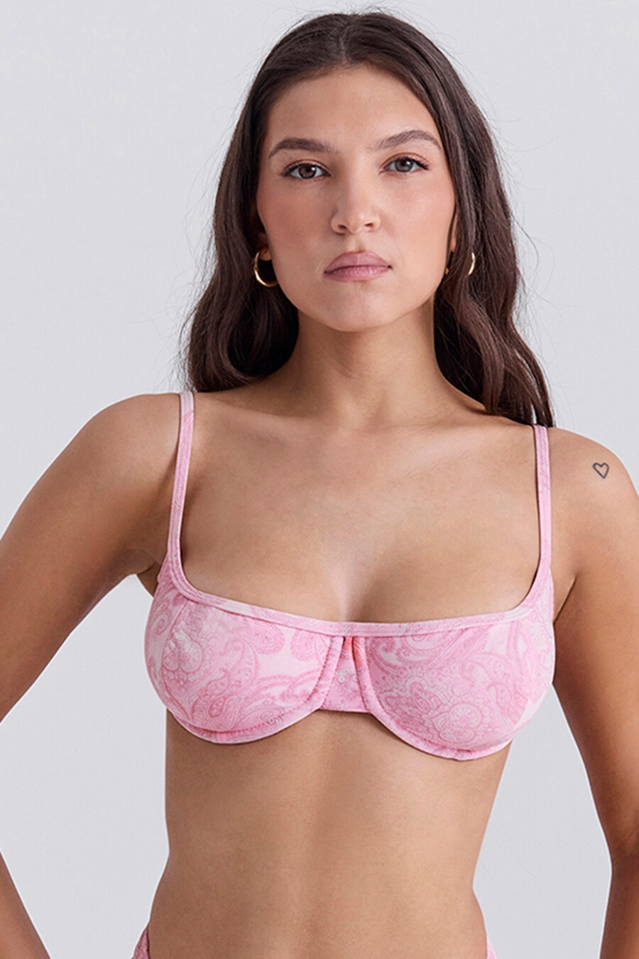 pinkfarbenes bikini-oberteil mit paisley-muster und bügeln